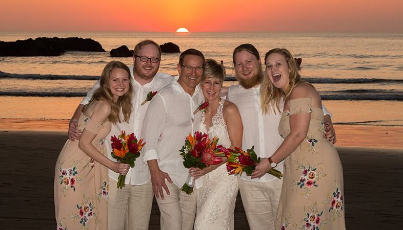 Wedding group in front of an ocean sunset